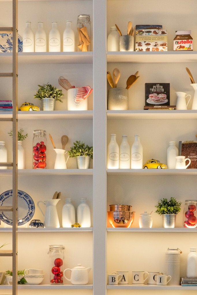 Étagères blanches décorées, vaisselle et jouets.